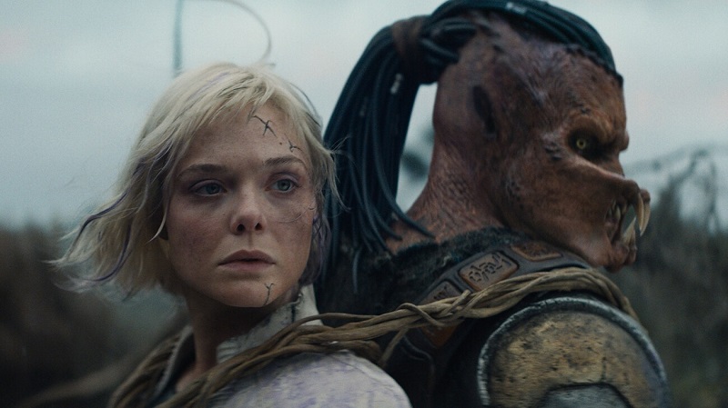 (L-R) Thia (Elle Fanning) and Dek (Dimitrius Schuster-Koloamatangi) in 20th Century Studios' PREDATOR: BADLANDS film. Photo courtesy of 20th Century Studios. © 2025 20th Century Studios.